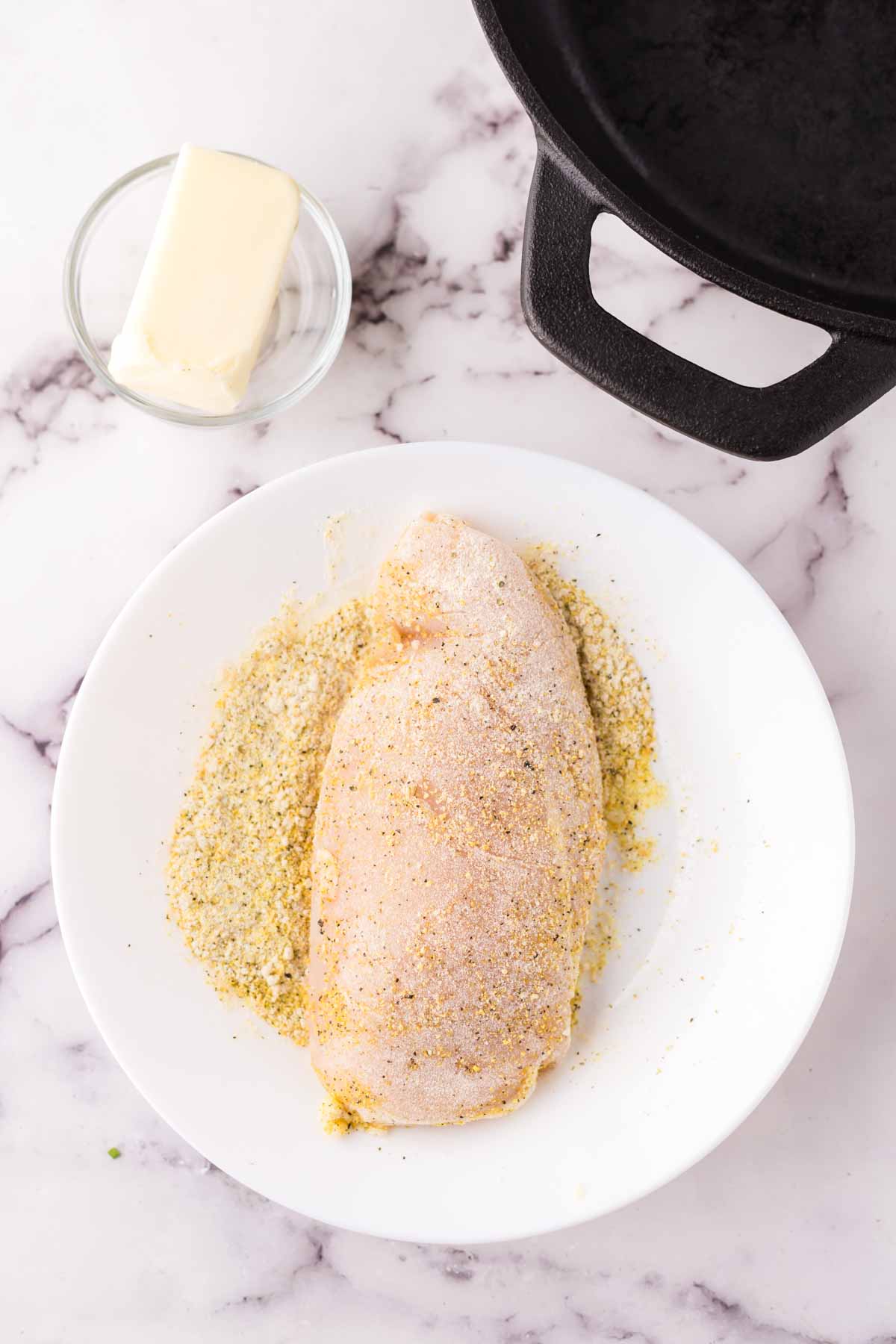 breaded raw chicken breast ready to make lemon pepper chicken recipe.