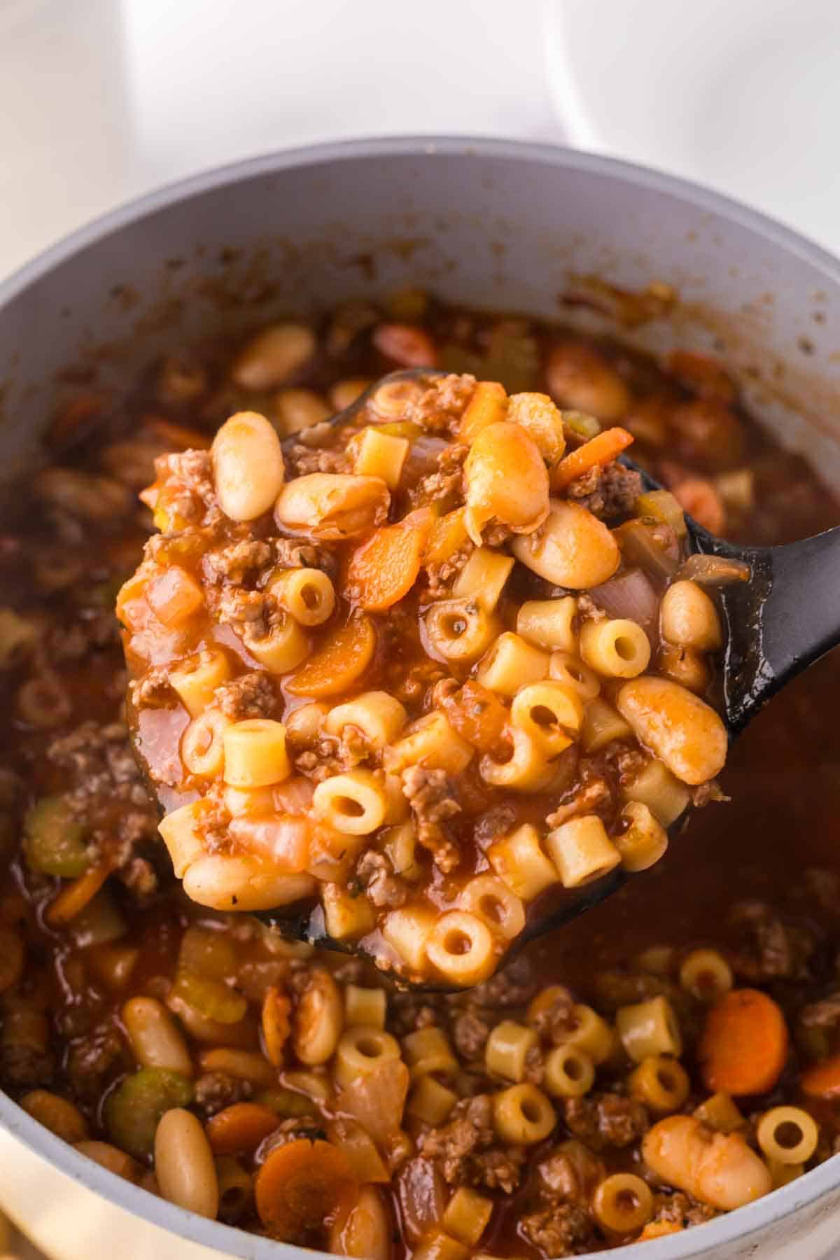 sauce pan with pasta fagioli soup recipe with a ladle in it.