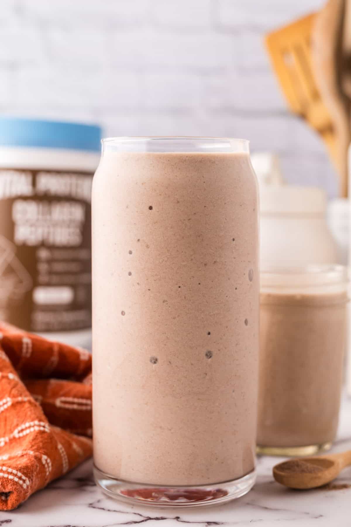 tall glass jar with a protein shake.