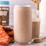 tall glass jar with a protein shake.