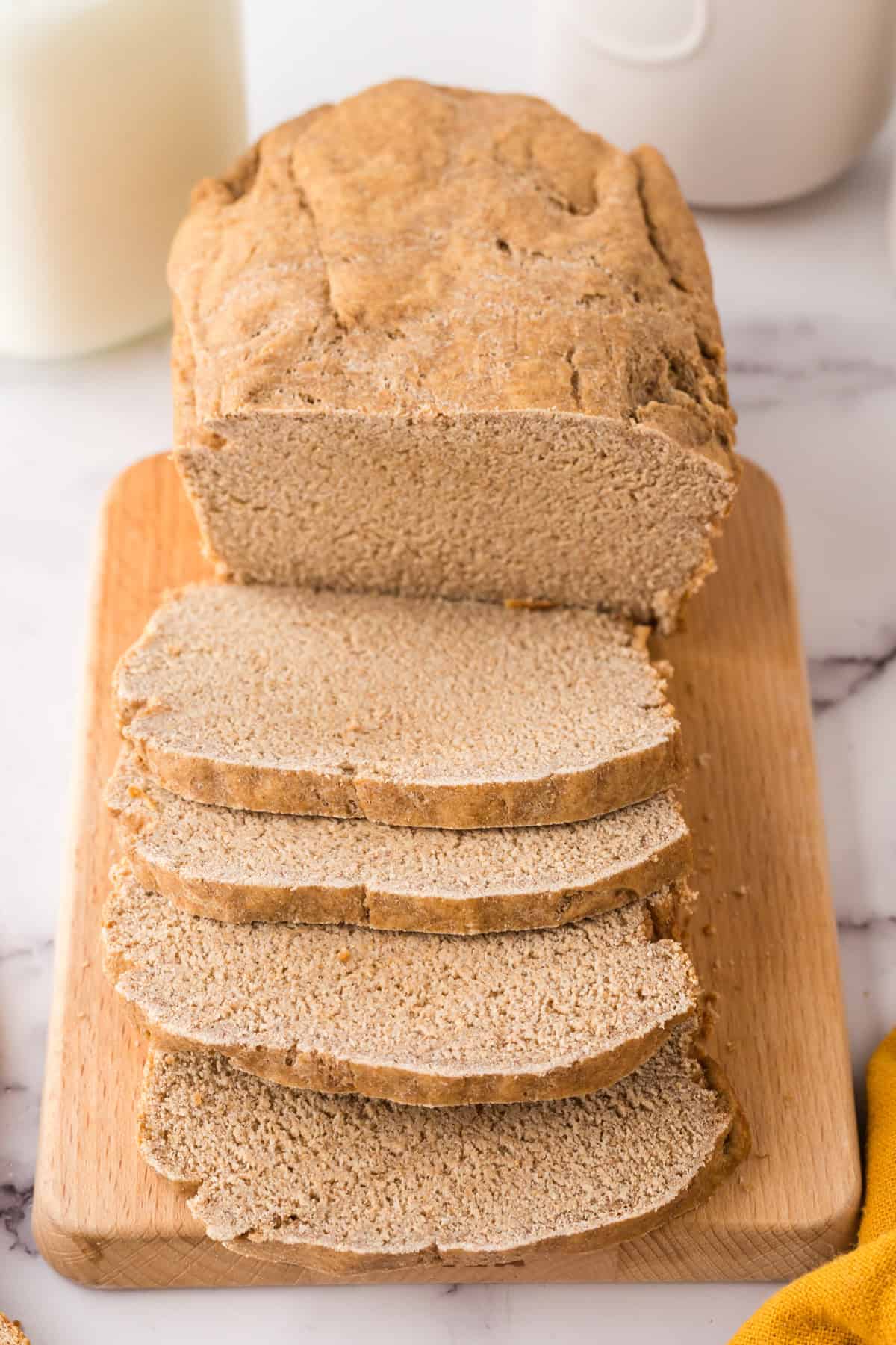 whole loaf with about half sliced and laid out of a fresh baked sandwich bread recipe.