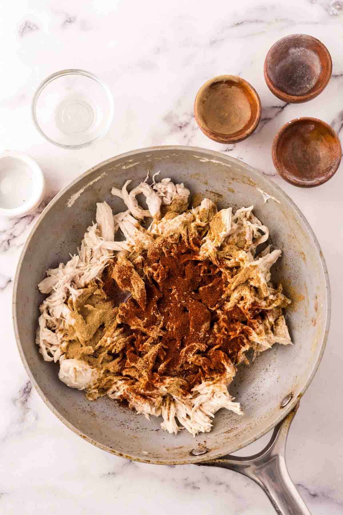 shredded chicken and seasonings in a pan.