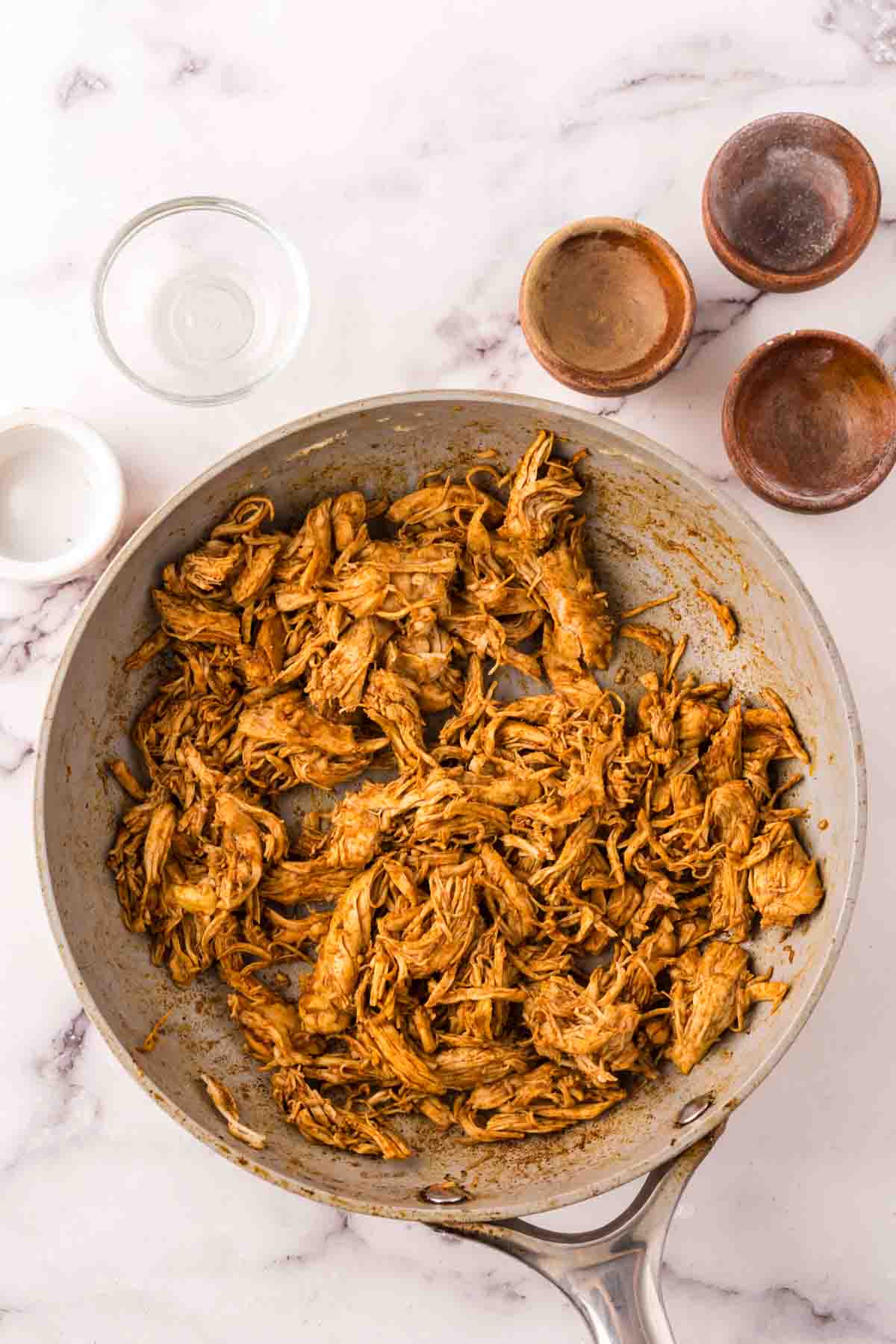 shredded chicken taco meat in a pan.