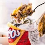 Fritos small chip bag with walking taco recipe inside with a fork full.