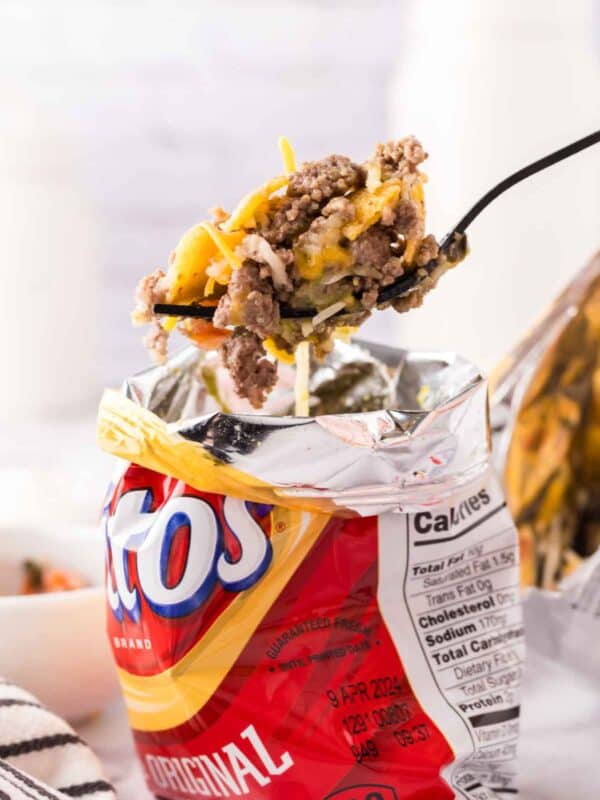 Fritos small chip bag with walking taco recipe inside with a fork full.