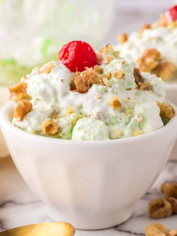 small dish with watergate salad recipe with nuts and a cherry on top.