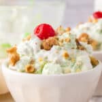 small dish with watergate salad recipe with nuts and a cherry on top.