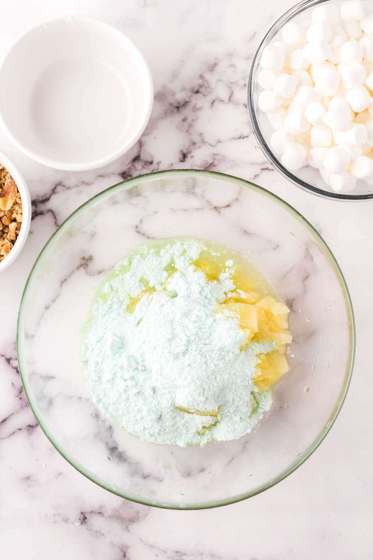 clear mixing bowl in the process of making watergate salad.