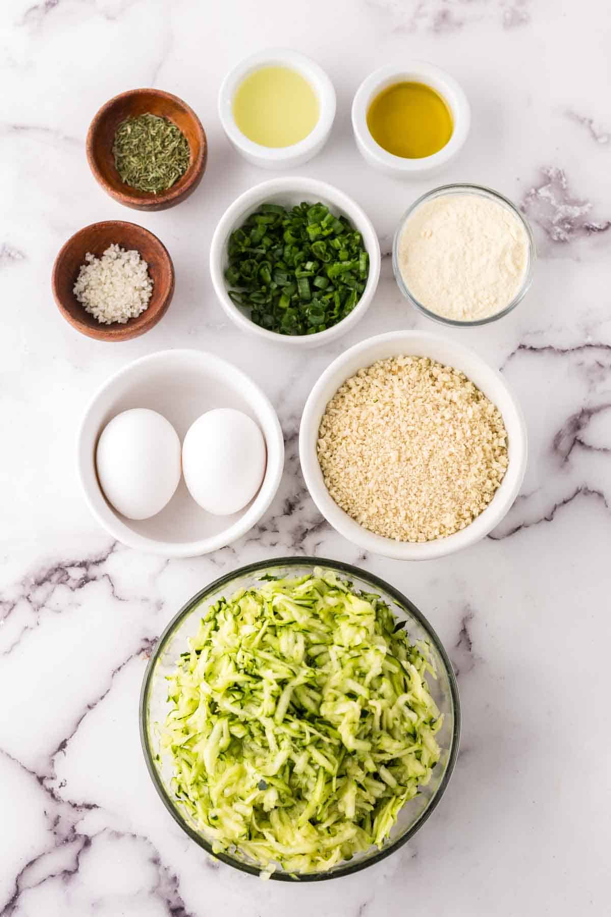 portion bowls each with raw ingredients to make zucchini fritters.