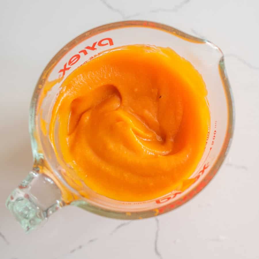 Clear glass measuring cup with sweet potato puree.