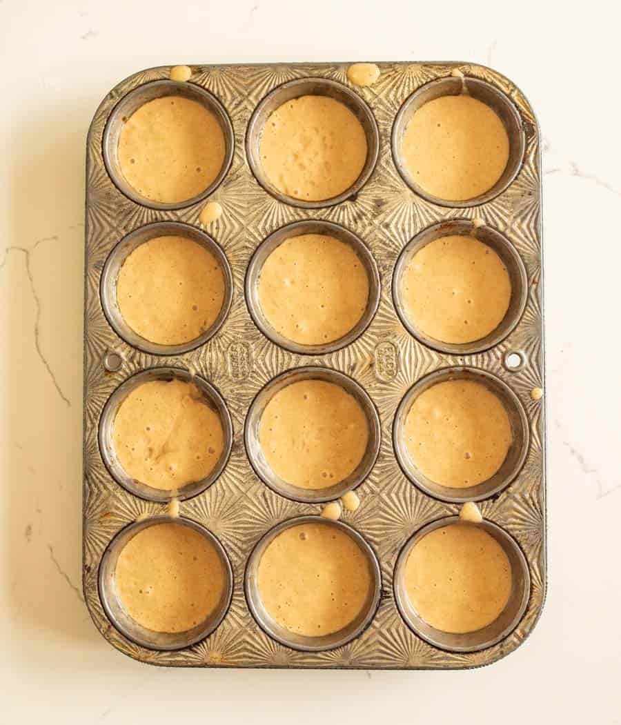 Sourdough muffin batter poured into a muffin pan before baking. 