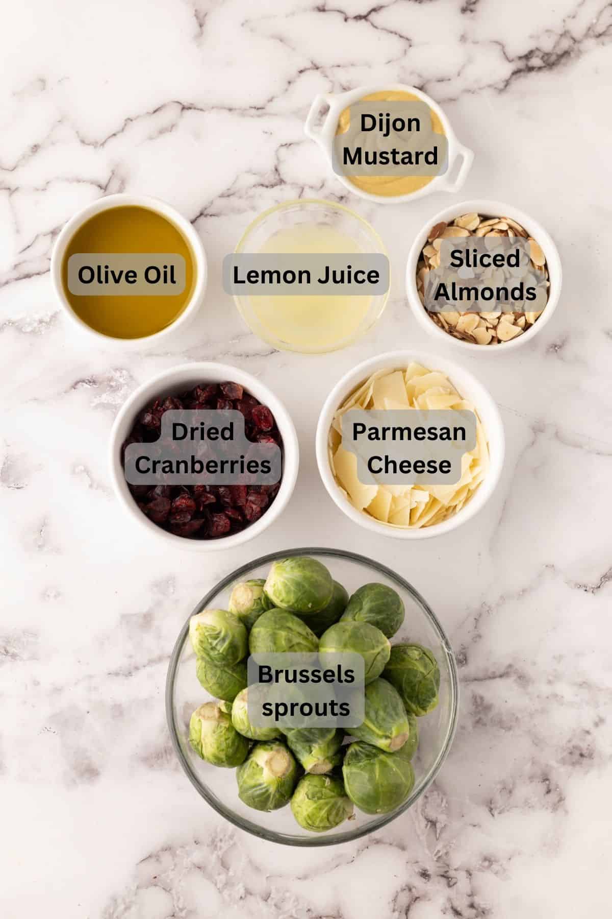 portion bowls each with digitally labeled raw ingredients to make brussels sprout salad recipe.