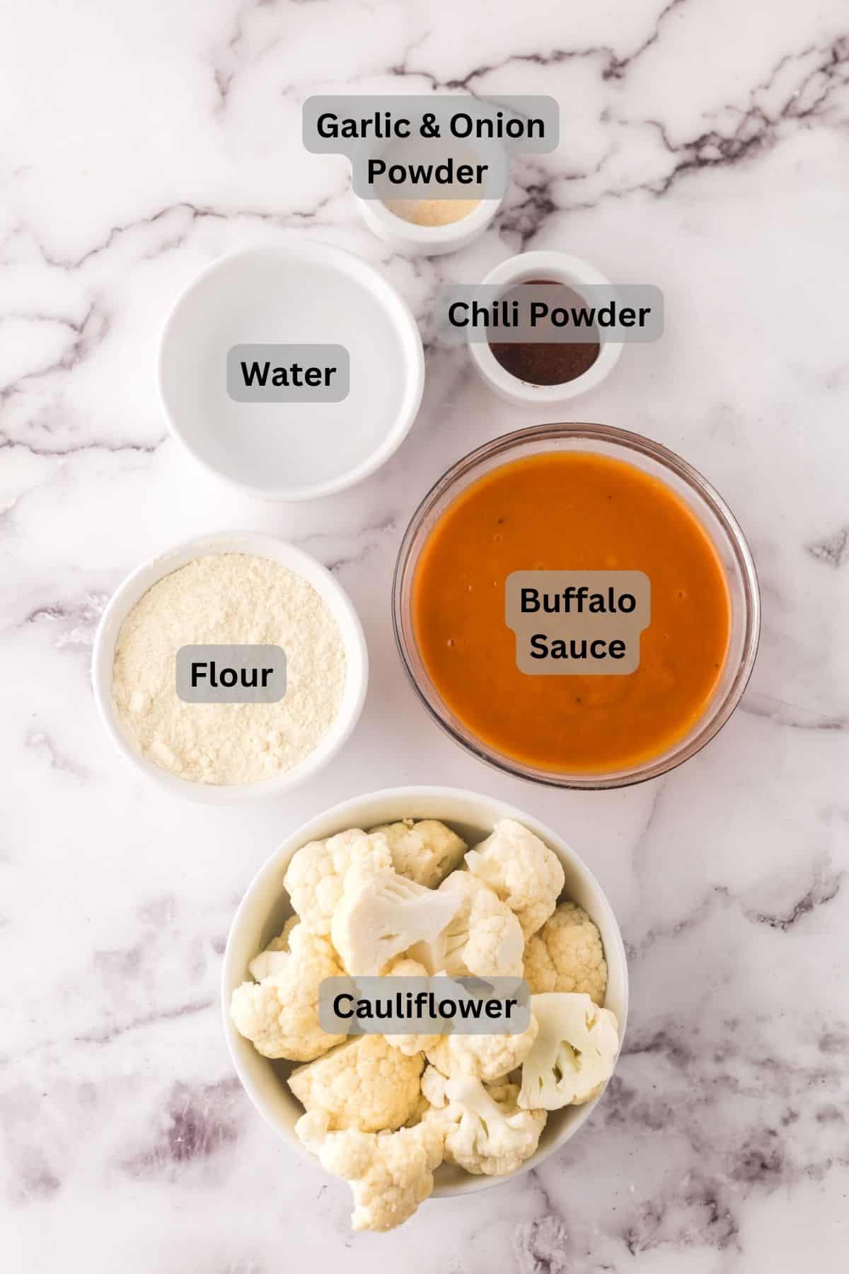 portion bowls each with digitally labeled raw ingredients to make buffalo cauliflower.