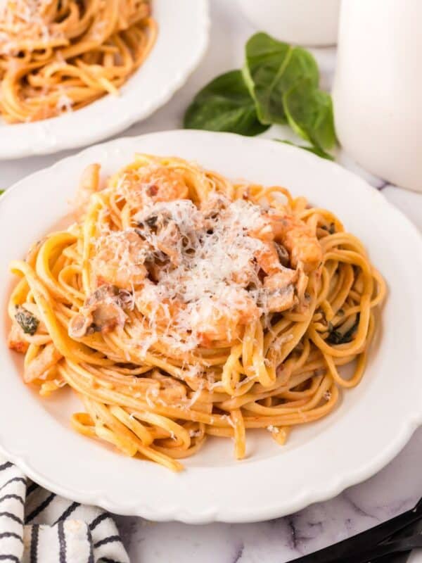 linguine rosa with shrimp on a round plate.