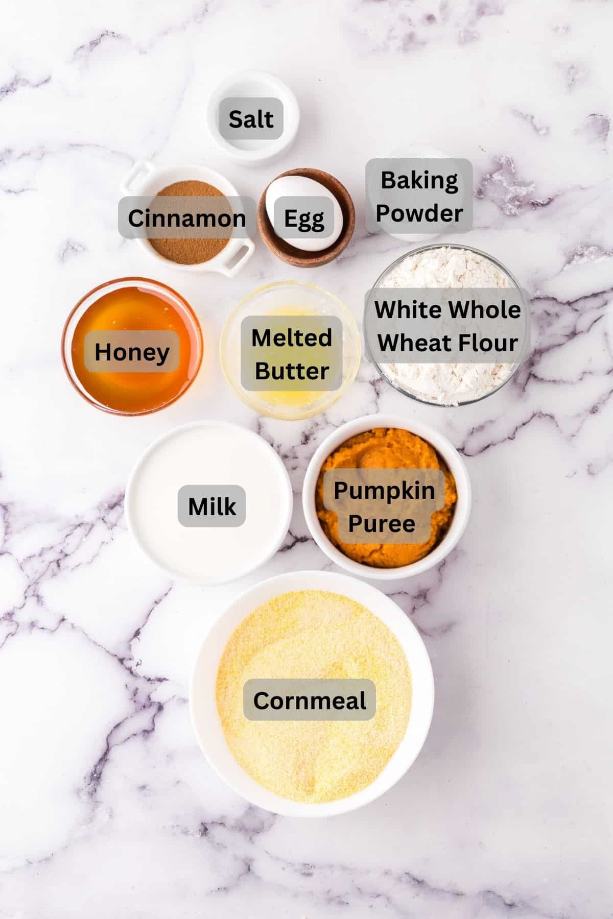portion bowls each with digitally labeled raw ingredients to make pumpkin cornbread muffins.