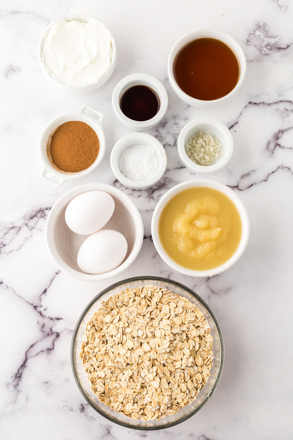 Ingredients separated in various bowls for making apple cinnamon muffins. 