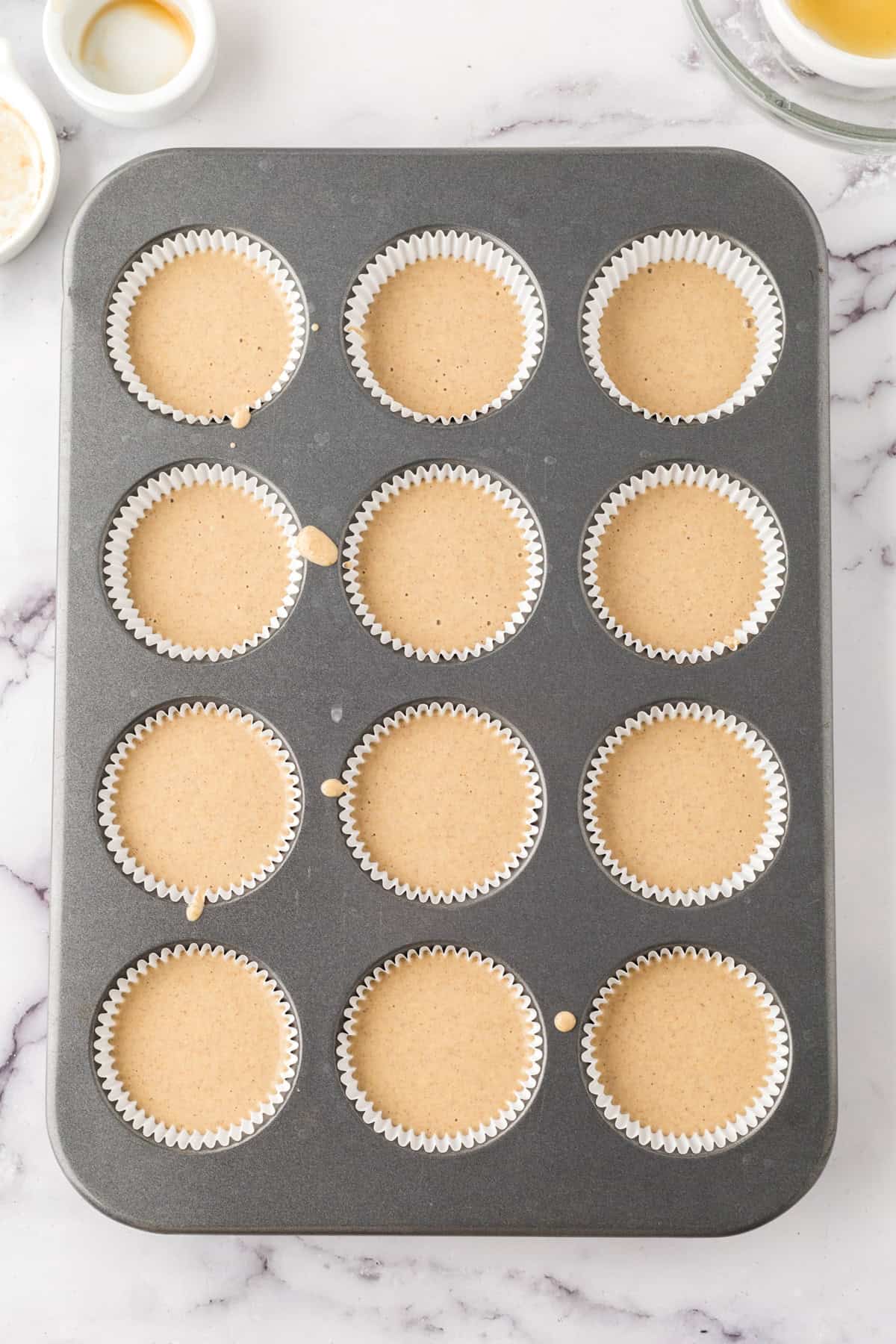 muffin tin filled with muffin batter. 