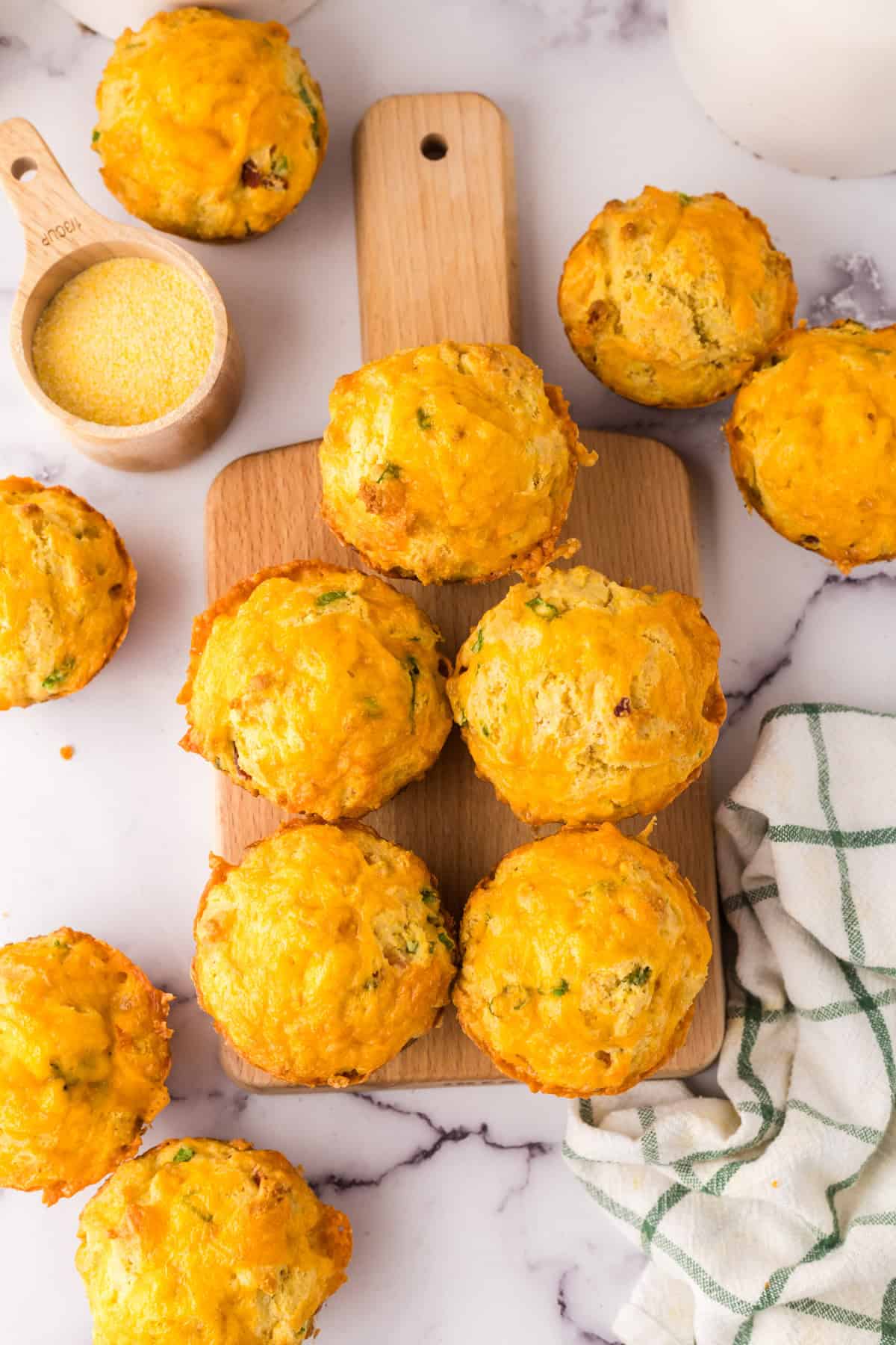 baked cheddar bacon cornbread muffins on a wooden board.