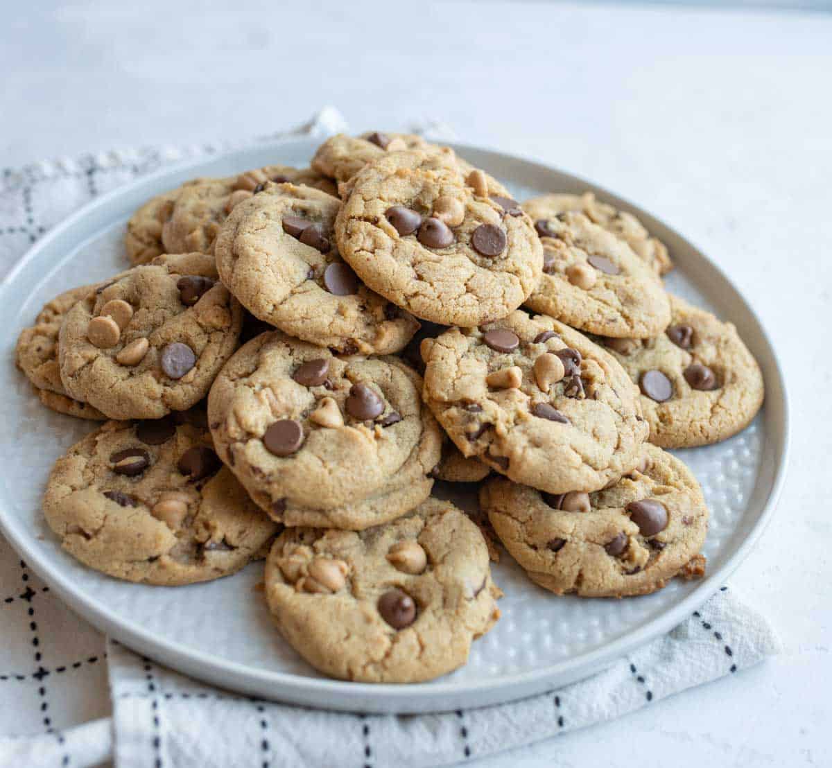 chocolate chip cookies with peanut butter chips in a pile on a round plate.