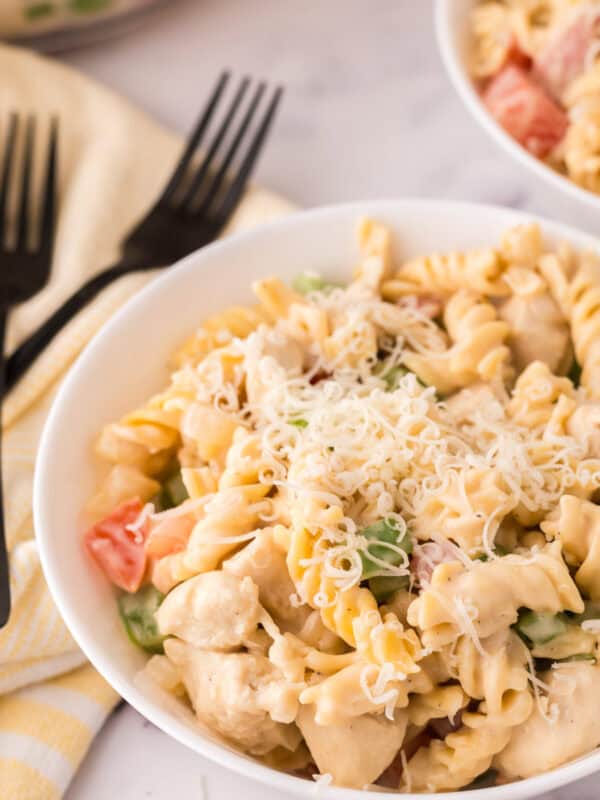 Creamy chicken bacon pasta in a white bowl with a black fork.