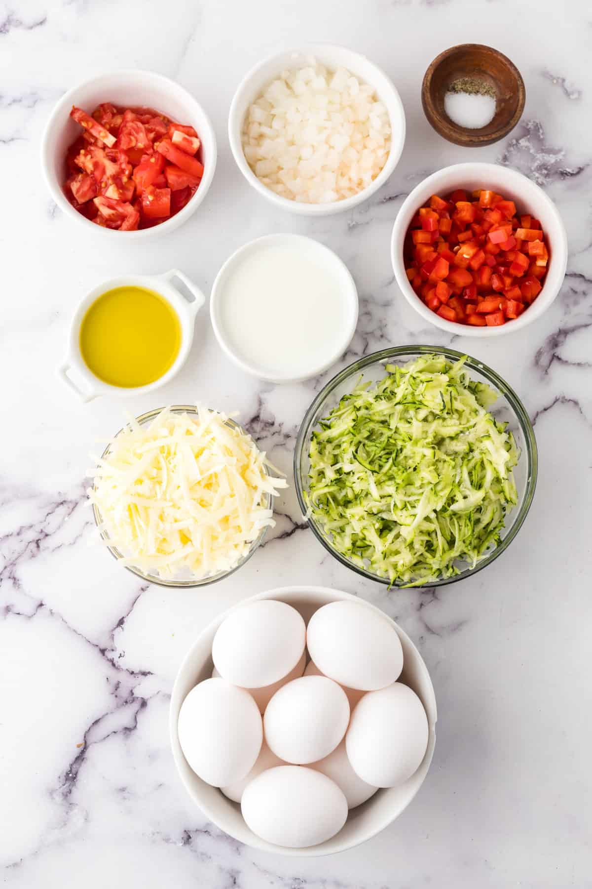 portion bowls each with raw ingredients to make farmhouse egg bake recipe.