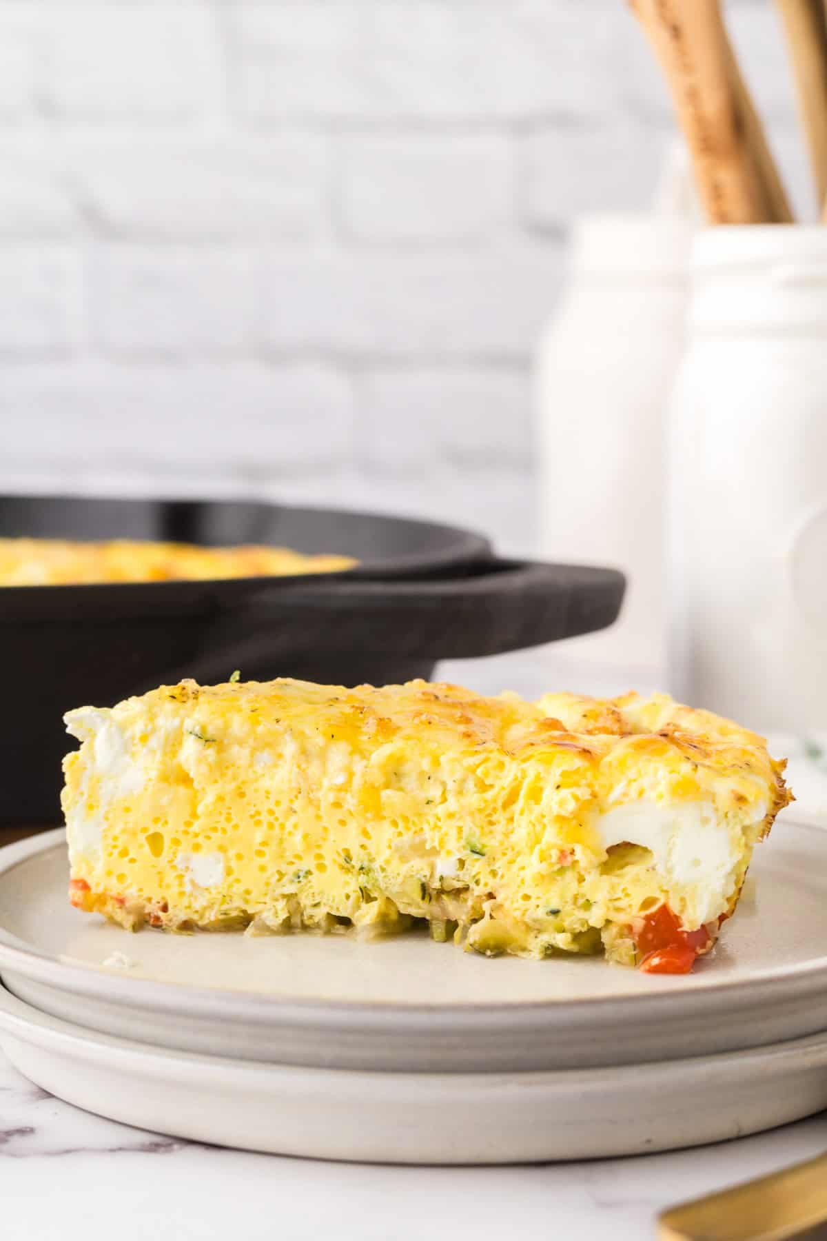 Farmhouse egg bake recipe in a triangle pie slice on a round plate with golden forks.