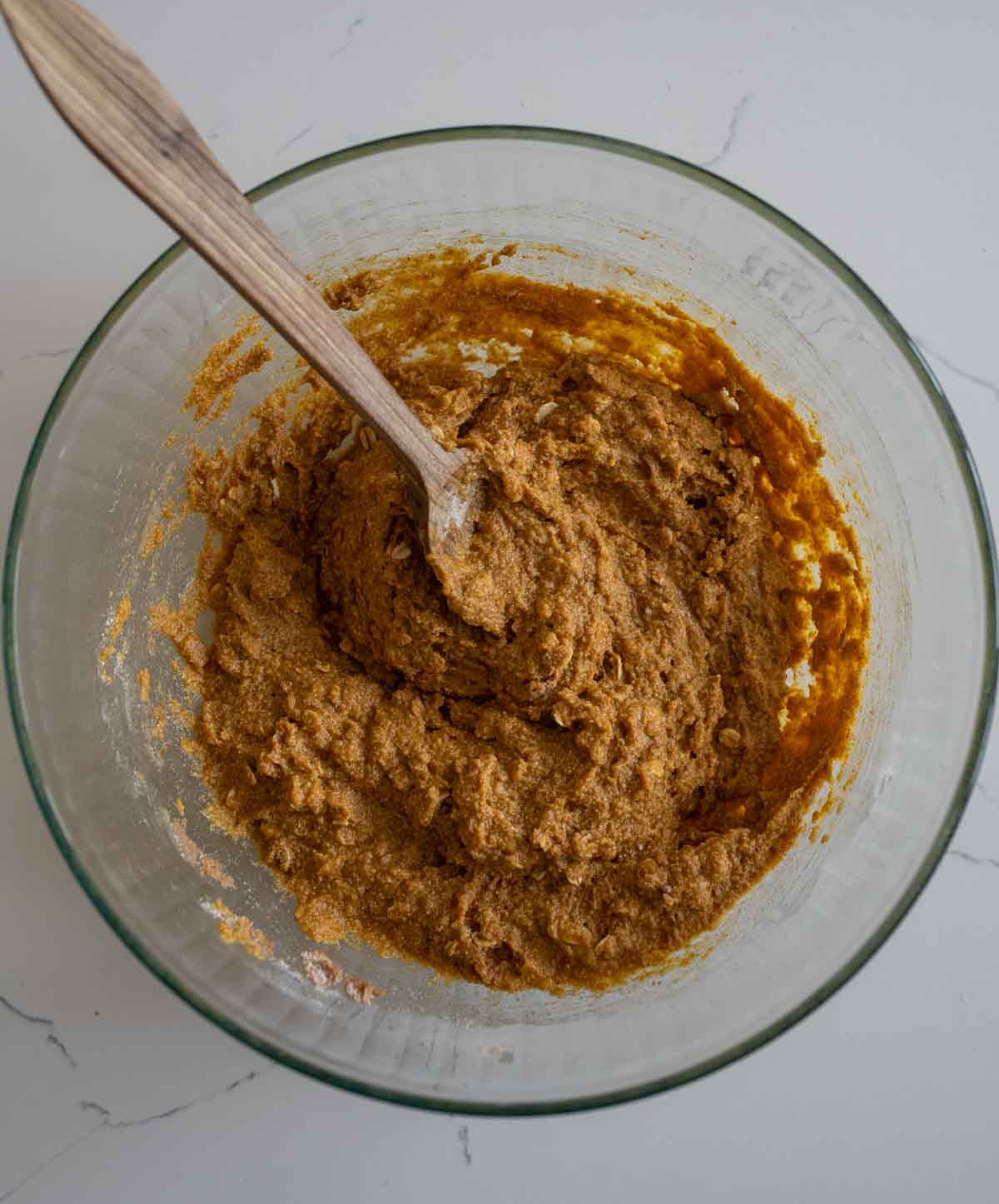 clear mixing bowl in the process of making healthy pumpkin muffins.