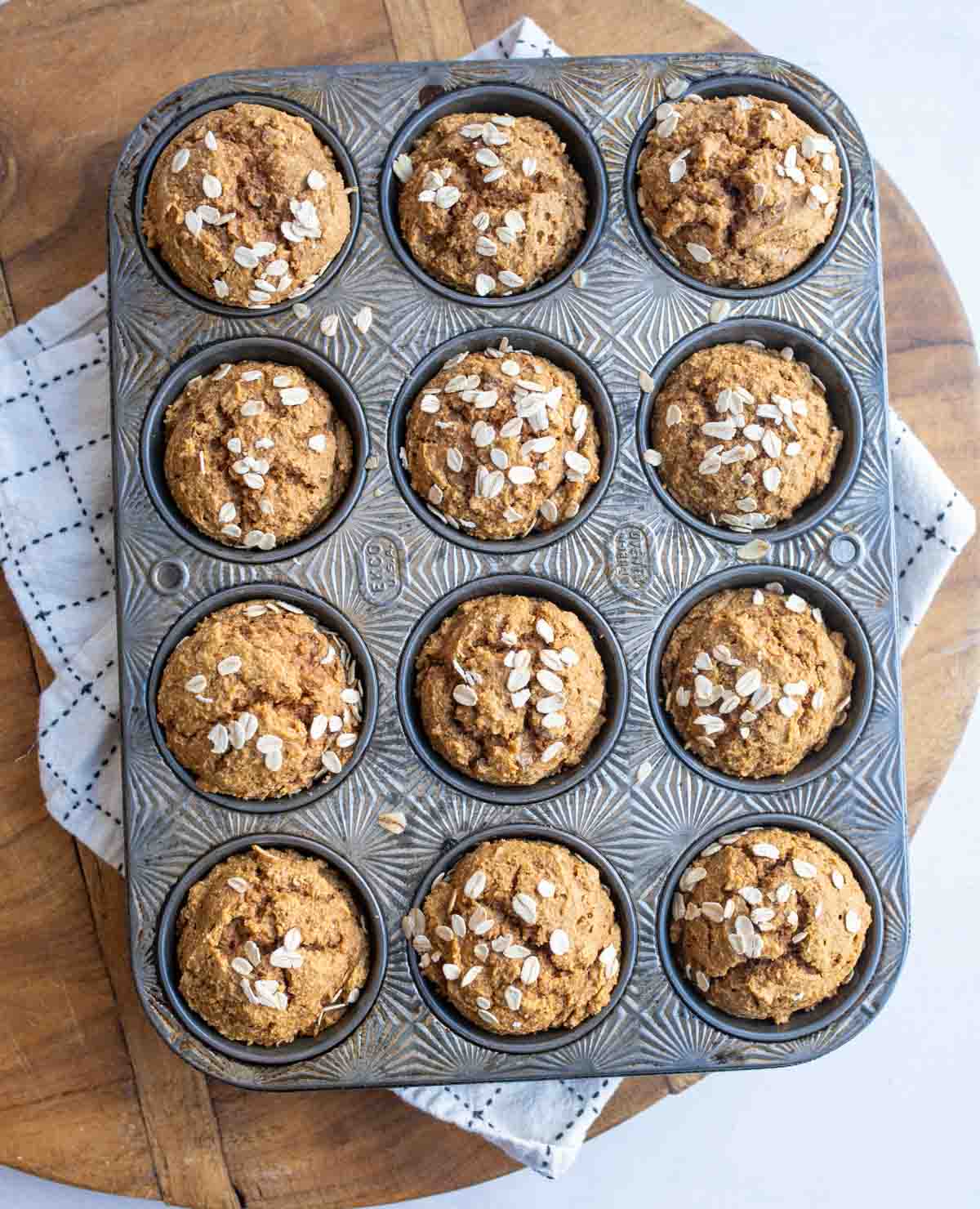 healthy pumpkin muffin dough into the tin with oats on top.