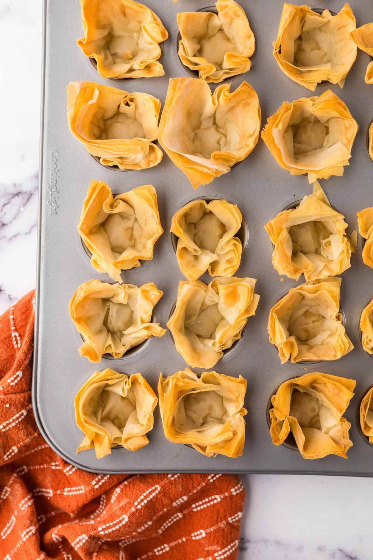 golden and crunchy homemade phyllo cups baked into a muffin tin.
