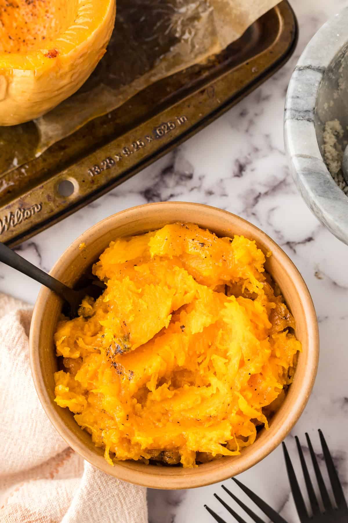 baked soft and smashed butternut squash in a small bowl.