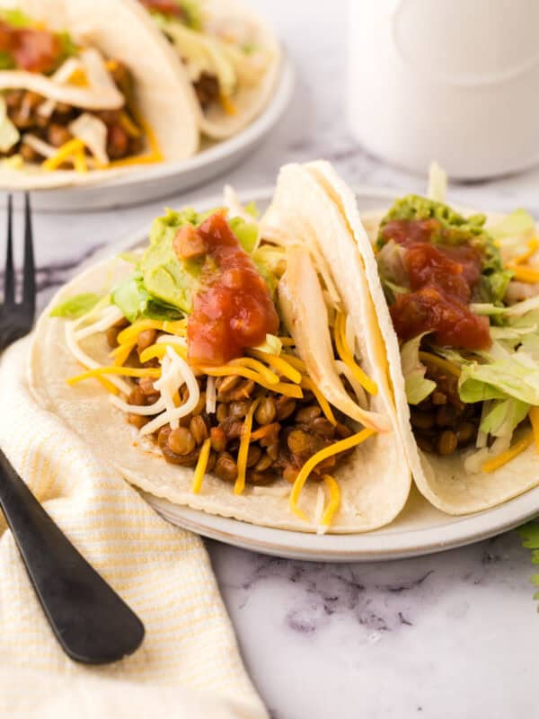 two lentil tacos on a white plate.