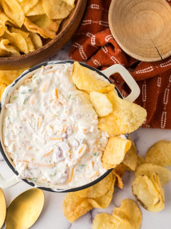loaded baked potato dip in a bowl with potato chips.