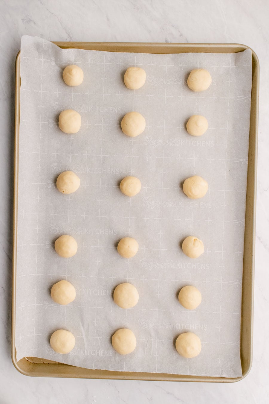 Melt away cookie dough balls on a sheet pan lined with parchment paper  ready to bake.