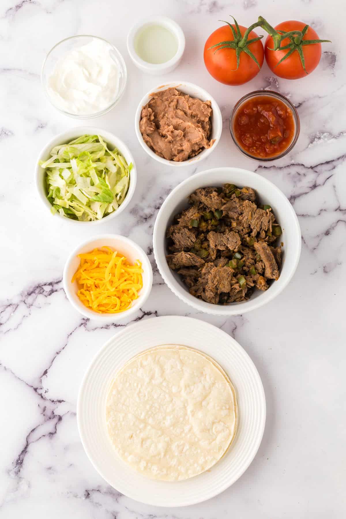 portion bowls each with raw ingredients to make Mexican beef tostado recipe.