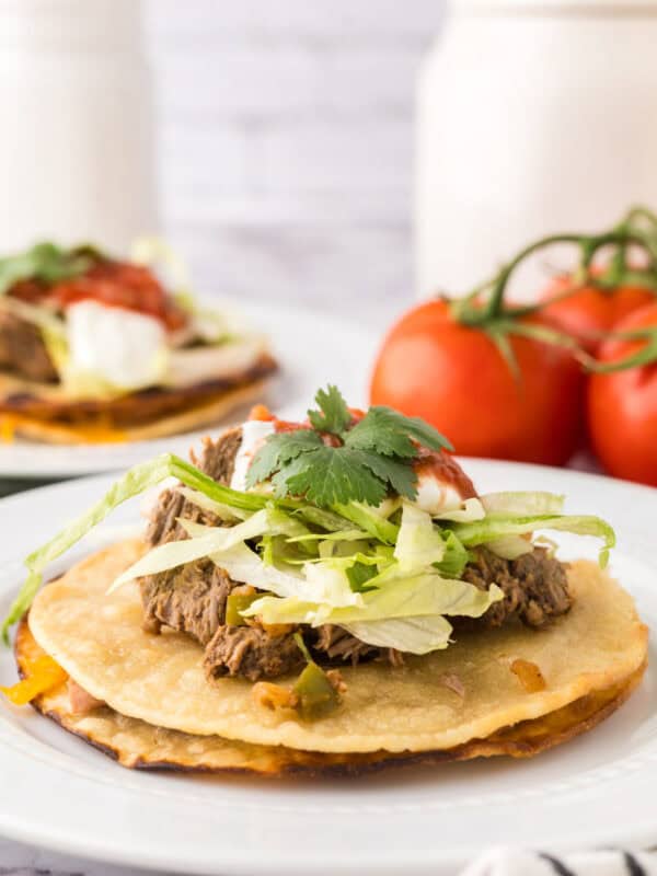 beef piled high with cilantro on top to make Mexican beef tostados.