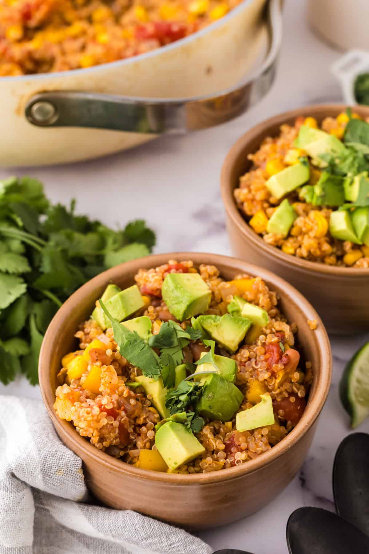 bowls with one pot quinoa taco casserole recipe with avocado and cilantro on top.