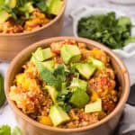 bowls with one pot quinoa taco casserole recipe with avocado and cilantro on top.