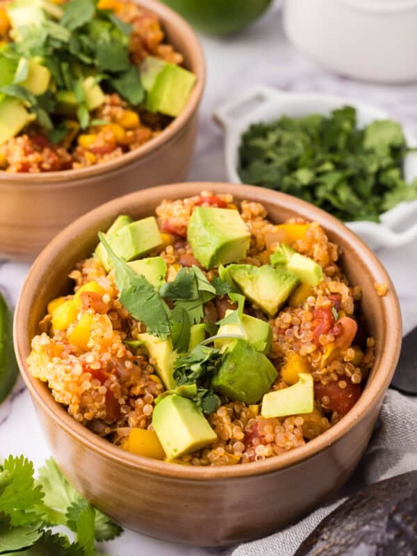 bowls with one pot quinoa taco casserole recipe with avocado and cilantro on top.