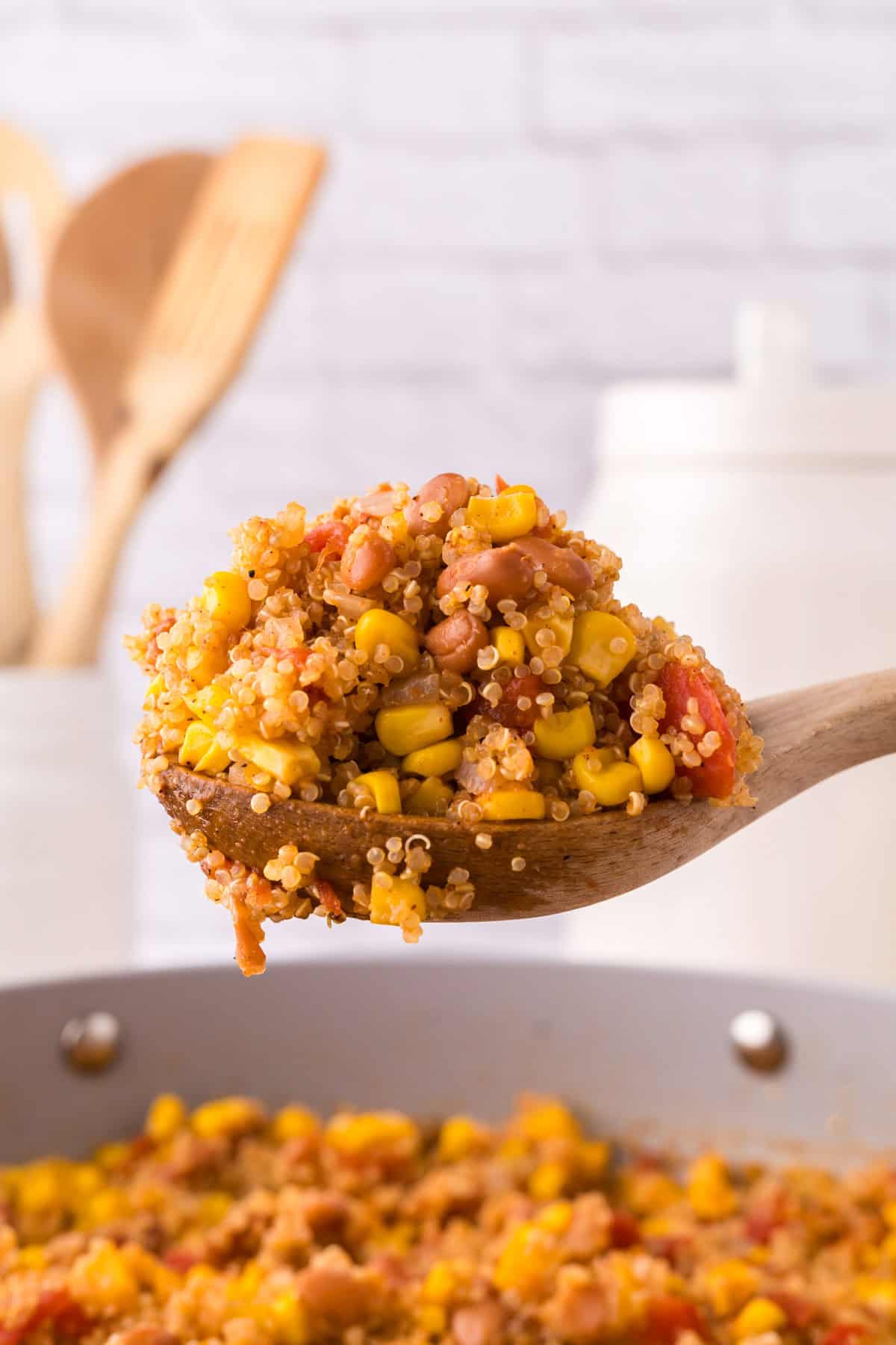 wooden spoon over a pan filled with one pot quinoa taco casserole recipe.