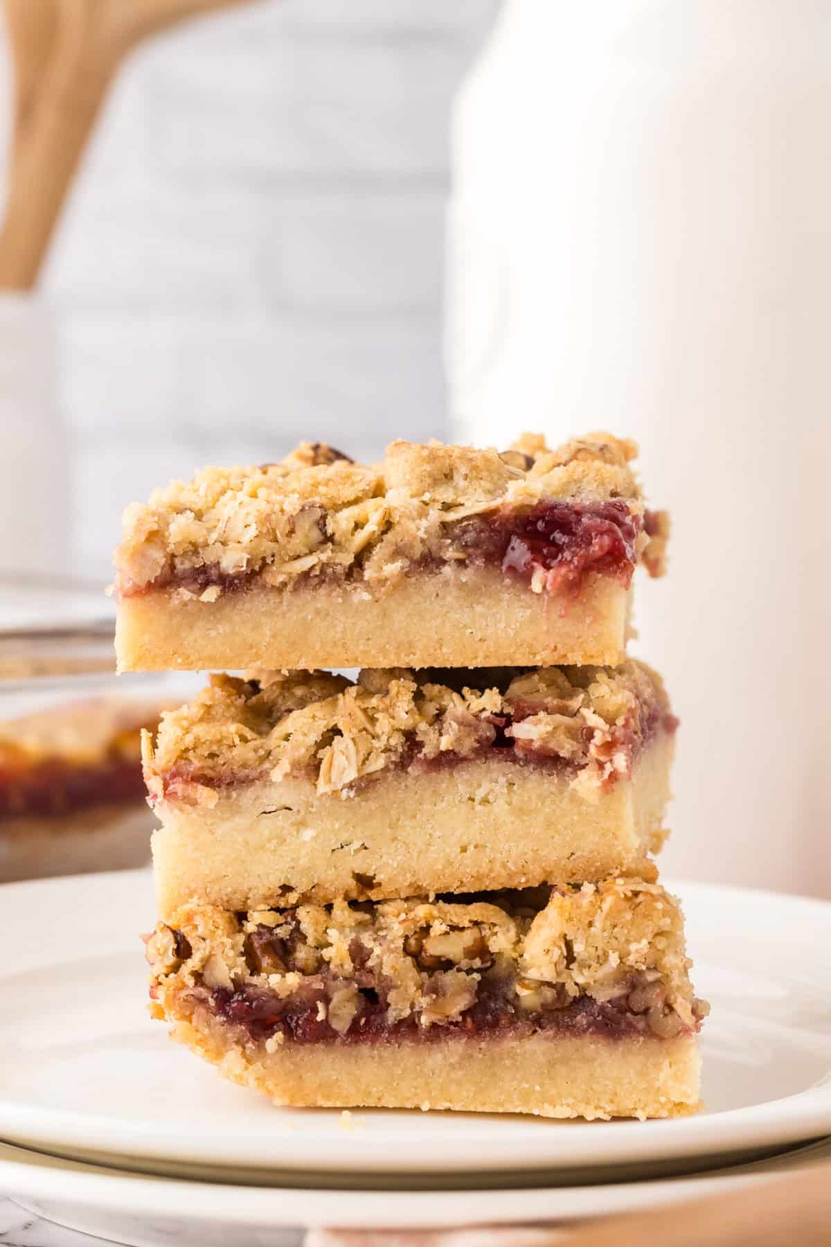 round white plate with a stack of square servings of raspberry streusel bars.