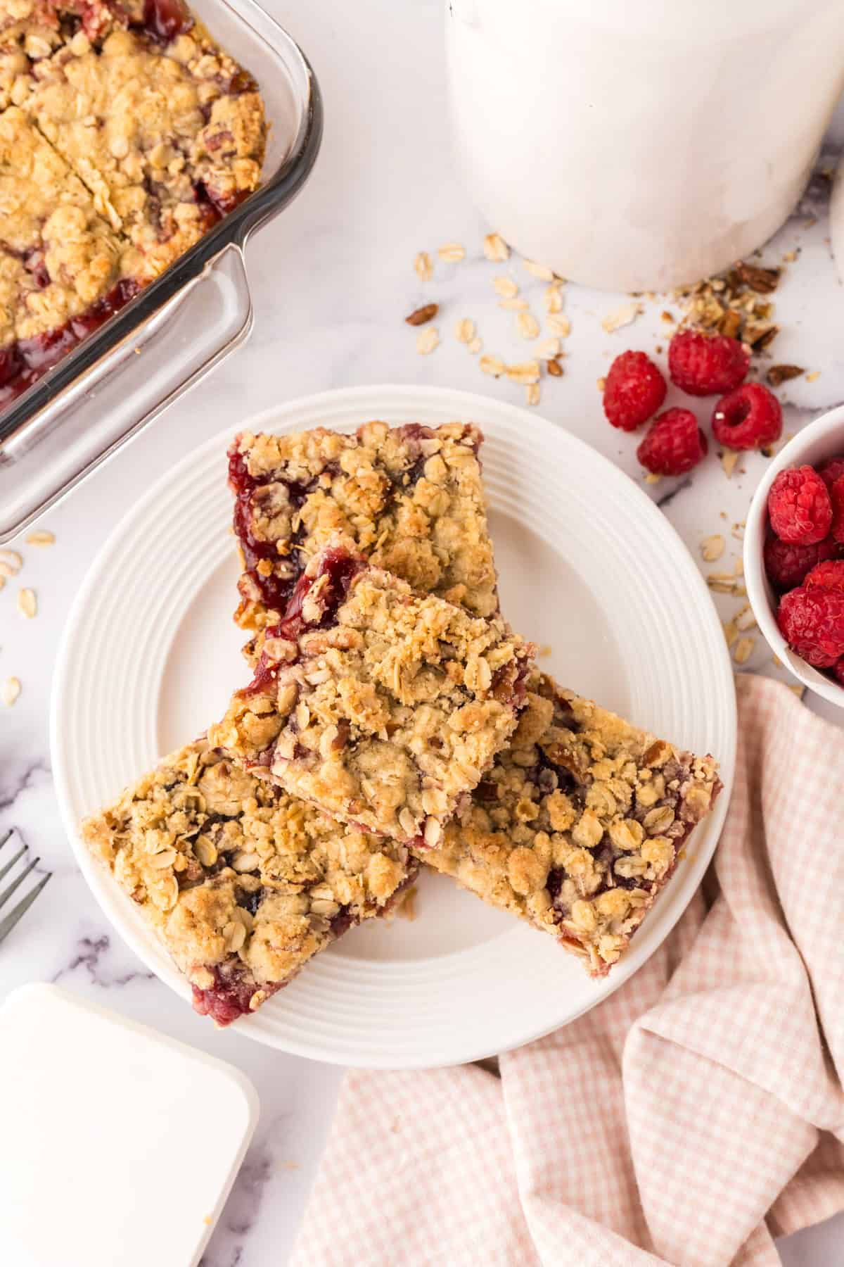 round white plate with squares of raspberry streusel bars.