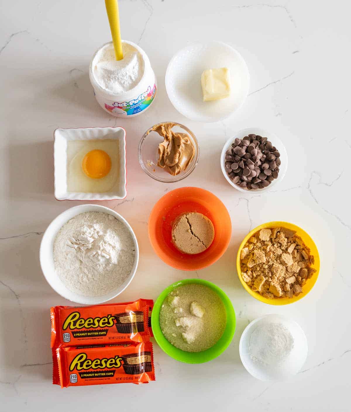 portion bowls each with raw ingredients to make Reeses S'mores Bars.