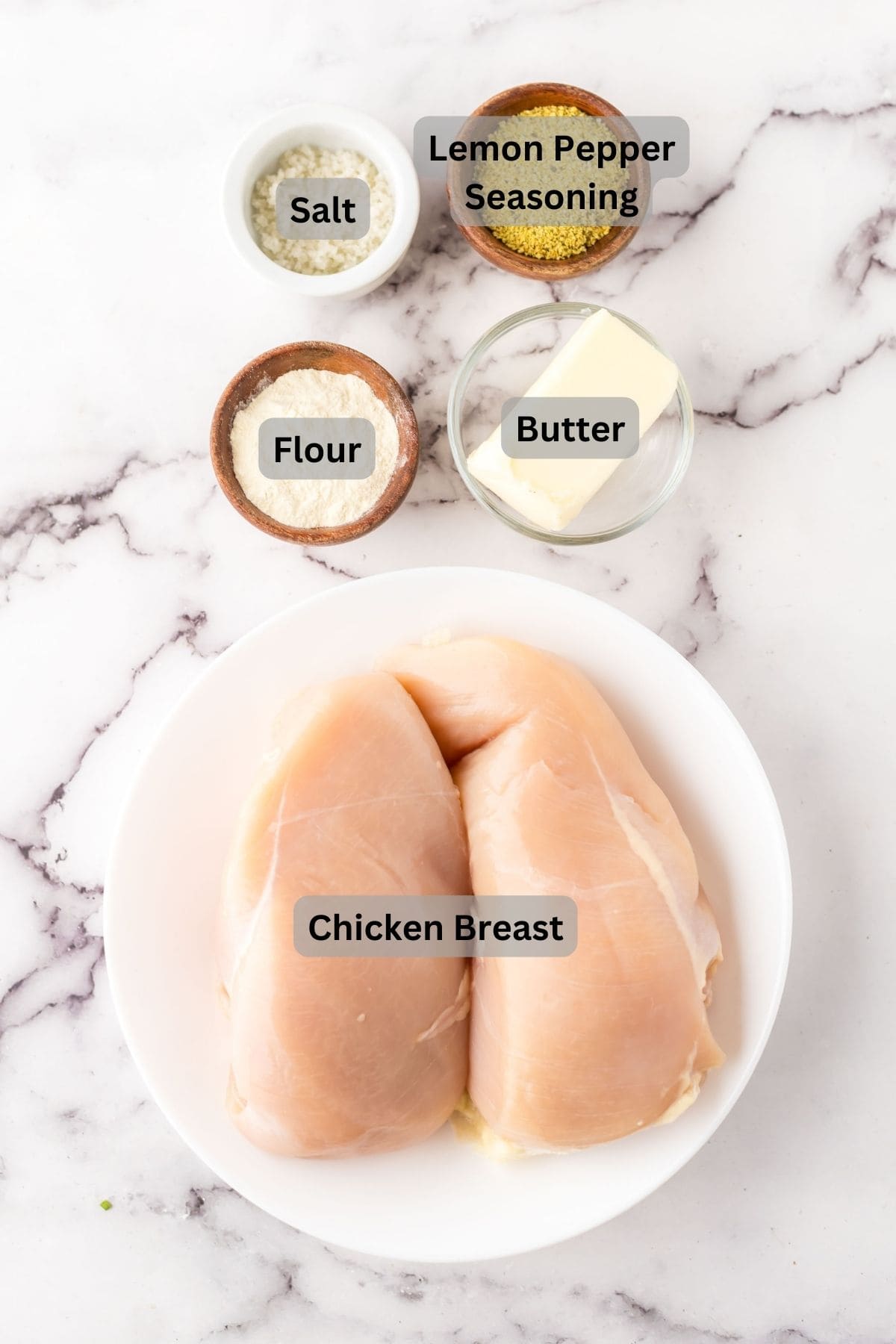 portion bowls each with digitally labeled raw ingredients to make lemon pepper chicken breasts.