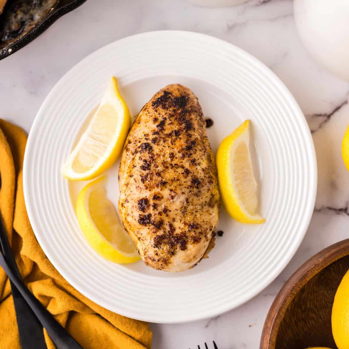 lemon peppered chicken on a round white plate.