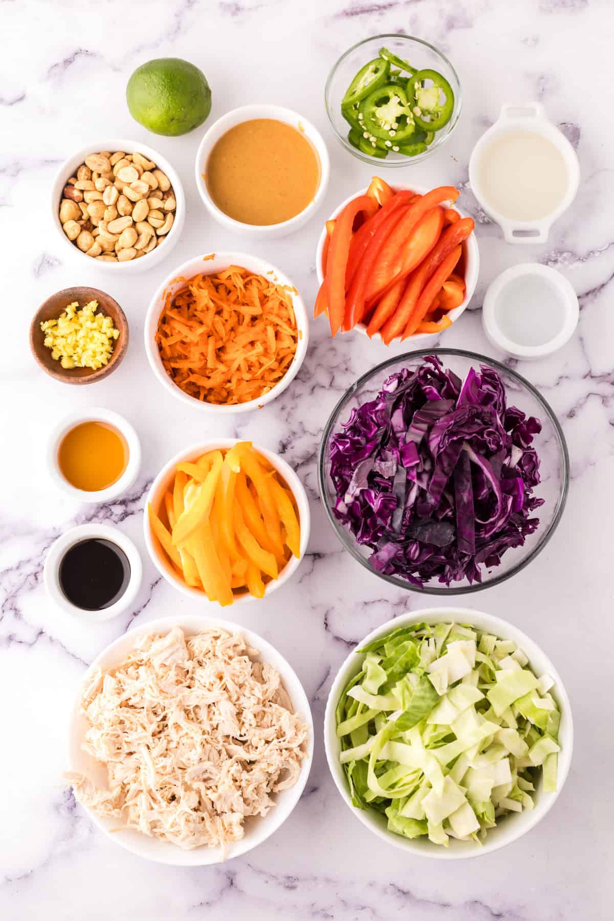 portion bowls each with raw ingredients to make asian chicken salad recipe.