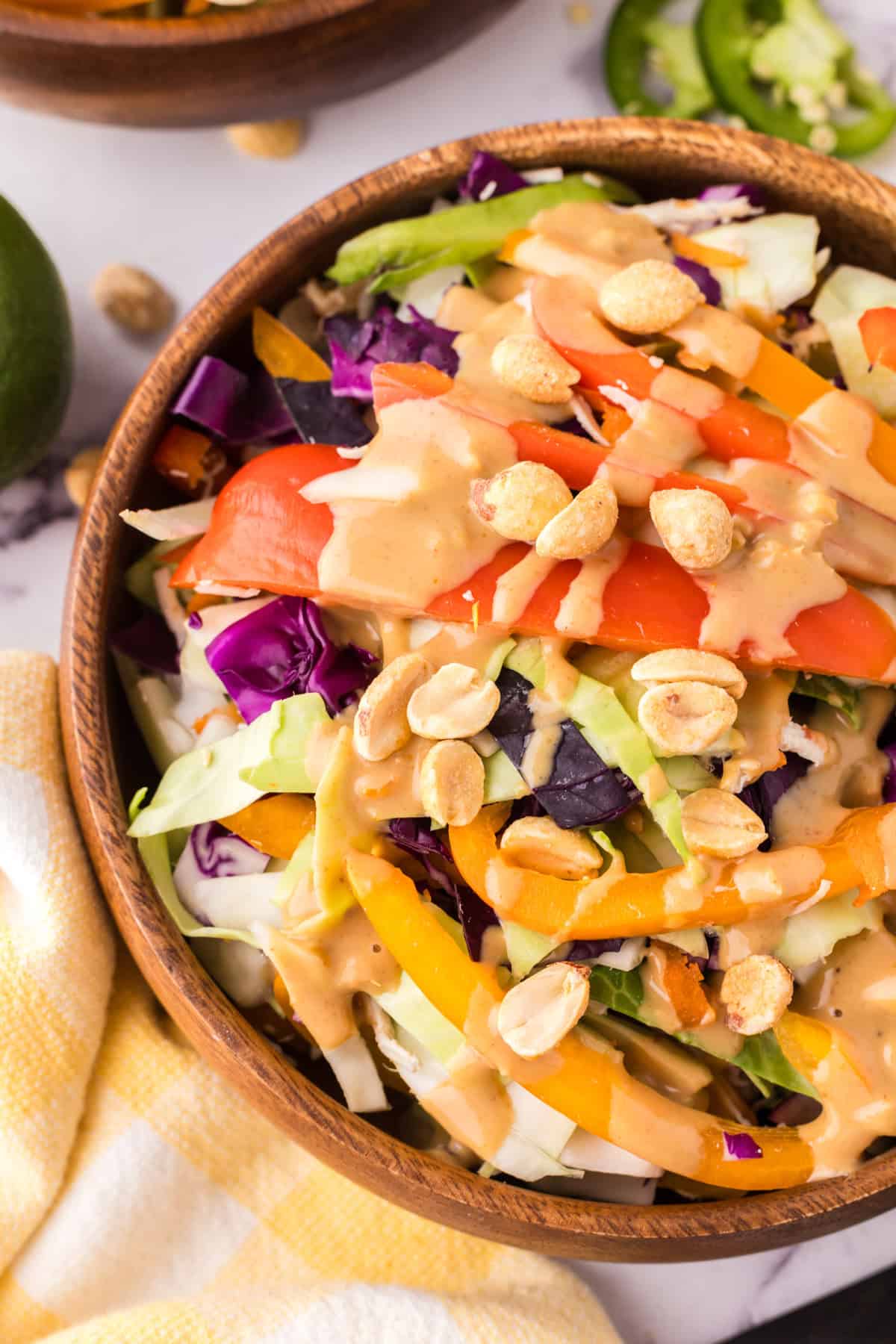 wooden salad bowl with asian chicken salad with peanut dressing.