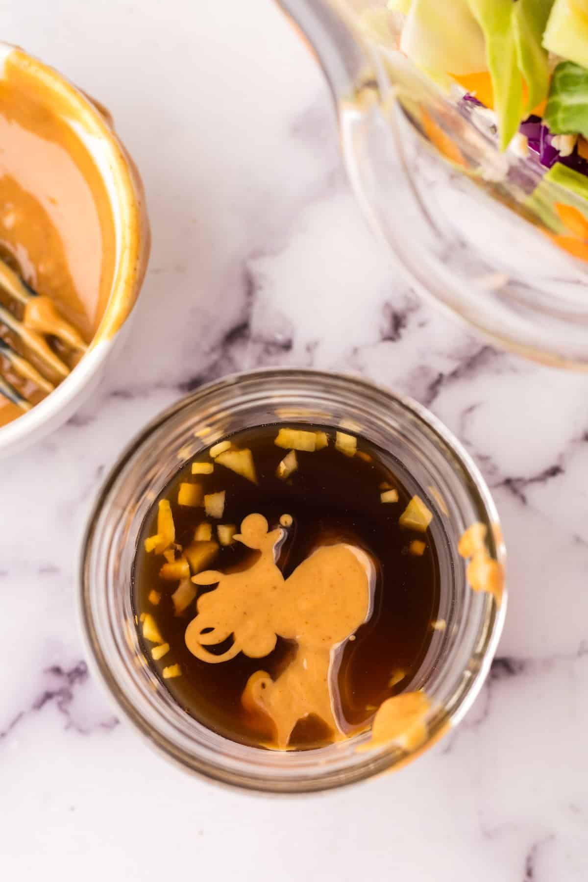 small mason jar in the process of making asian chicken salad's peanut dressing.