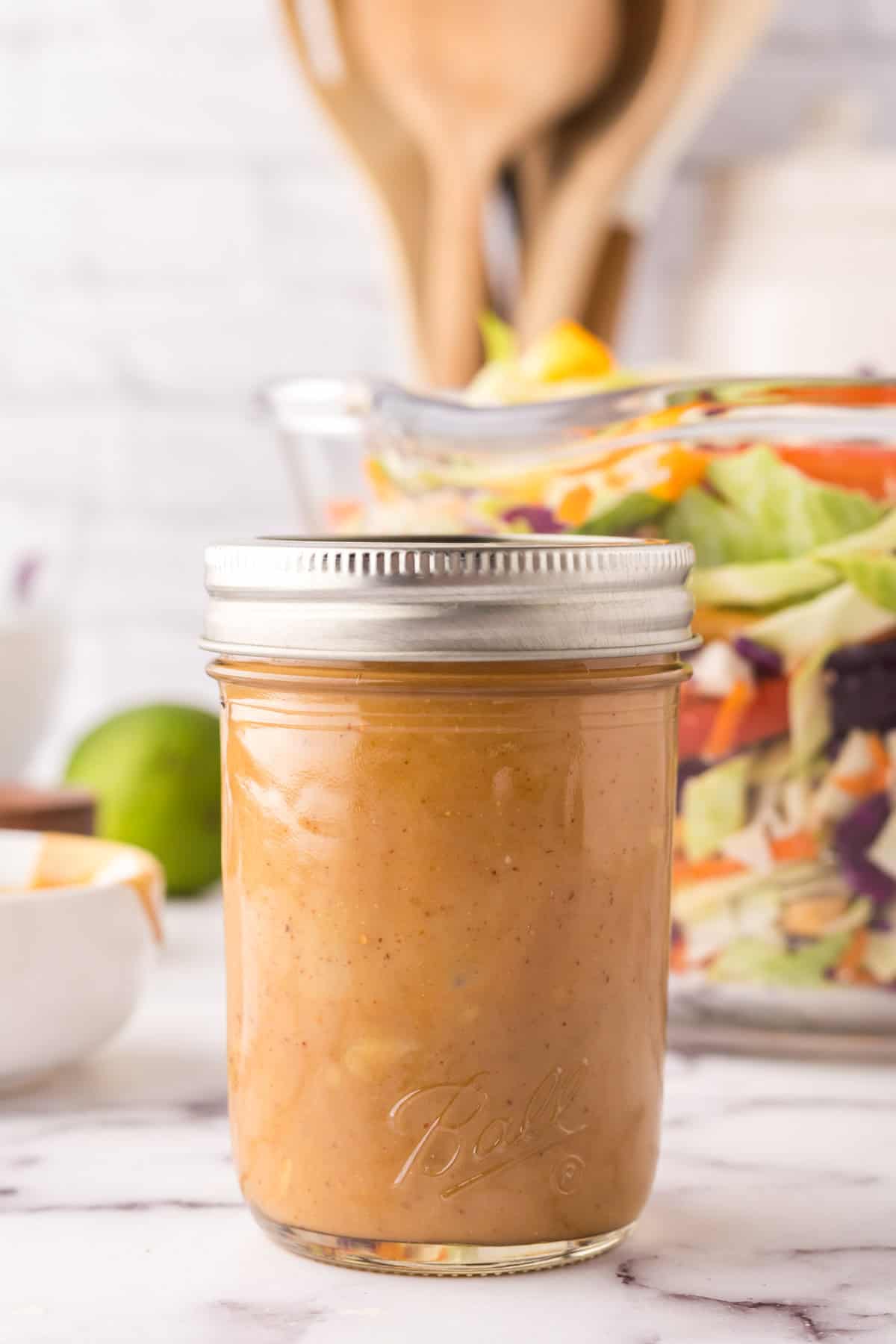 small mason jar with peanut dressing for asian chicken salad.