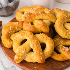 wooden board with a pile of big soft pretzels.