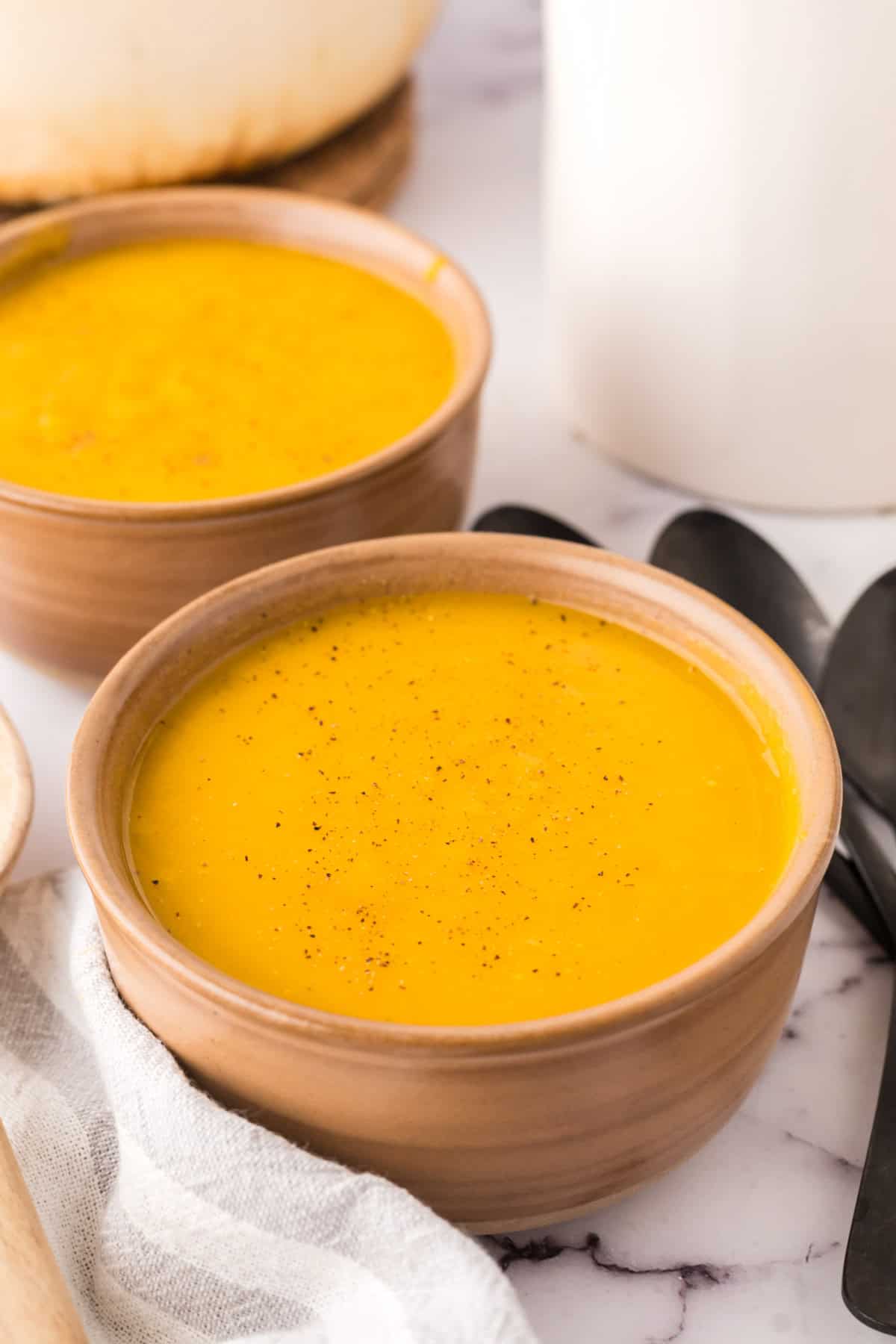 homemade butternut squash soup in two serving bowls.